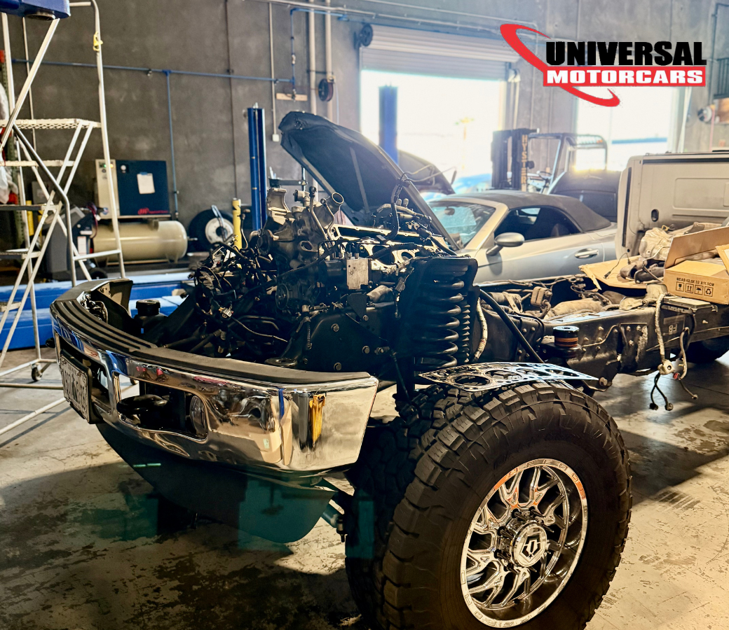 Exposed engine and chassis during major mechanical work in the Universal Motorcars workshop