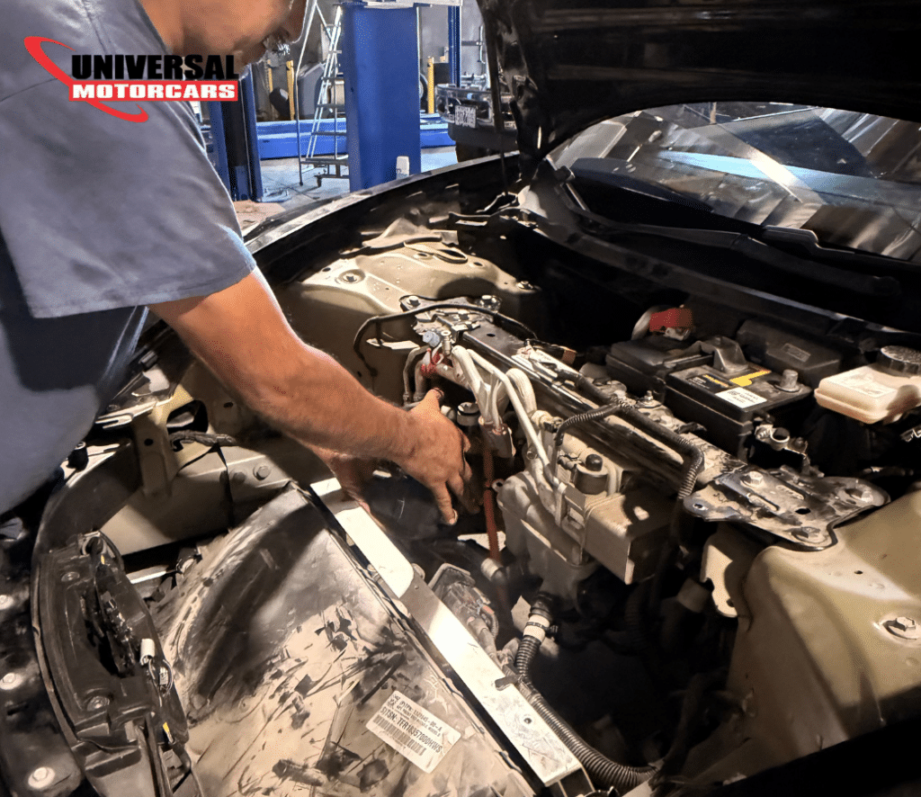 Technician replacing a Tesla A/C compressor at Universal Motorcars in Las Vegas.