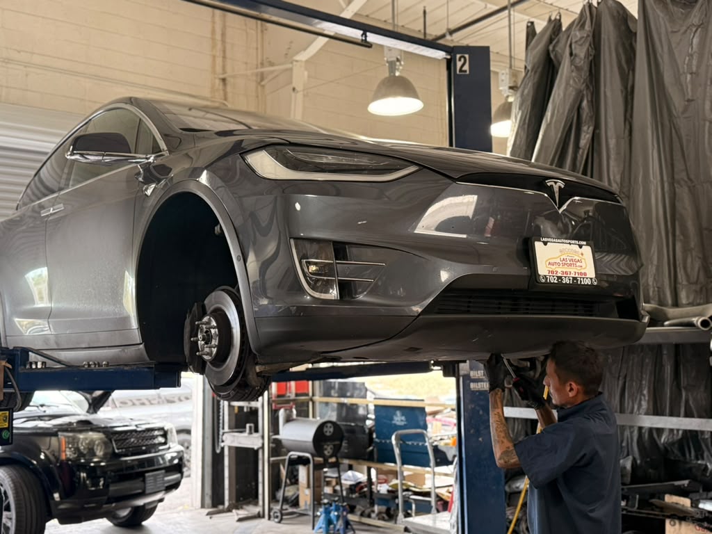 Universal Motorcars technician performing Tesla Model X brake and suspension repair in Las Vegas