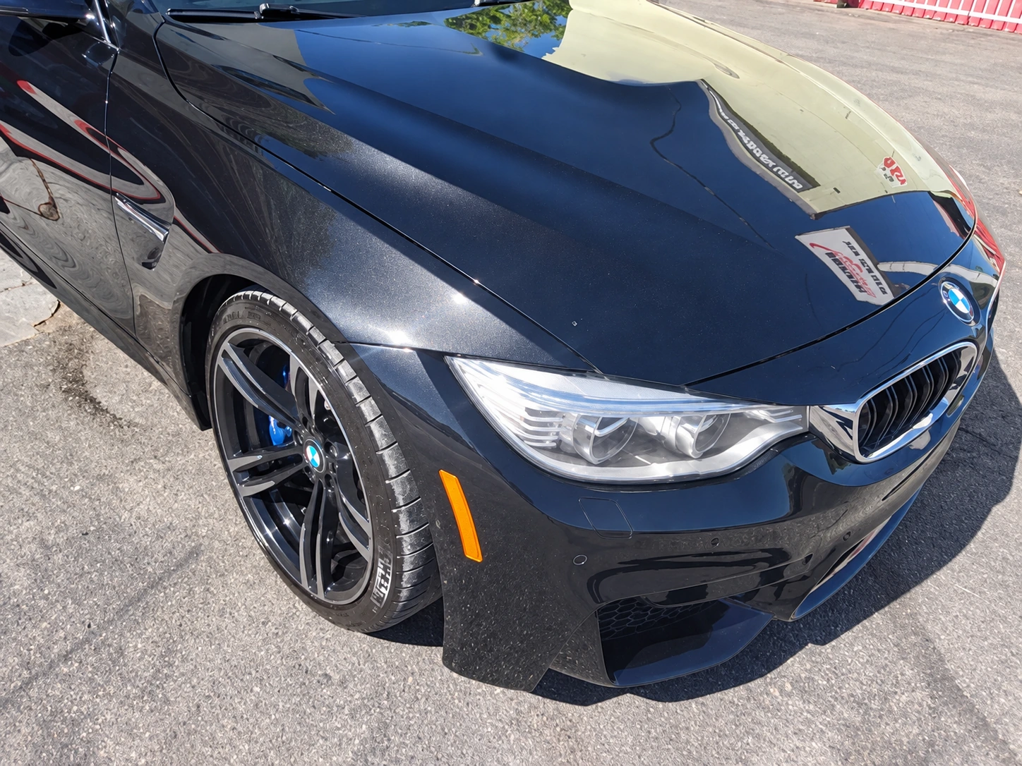 Blue BMW with its hood and front bumper restored after collision repair at Universal Motorcars