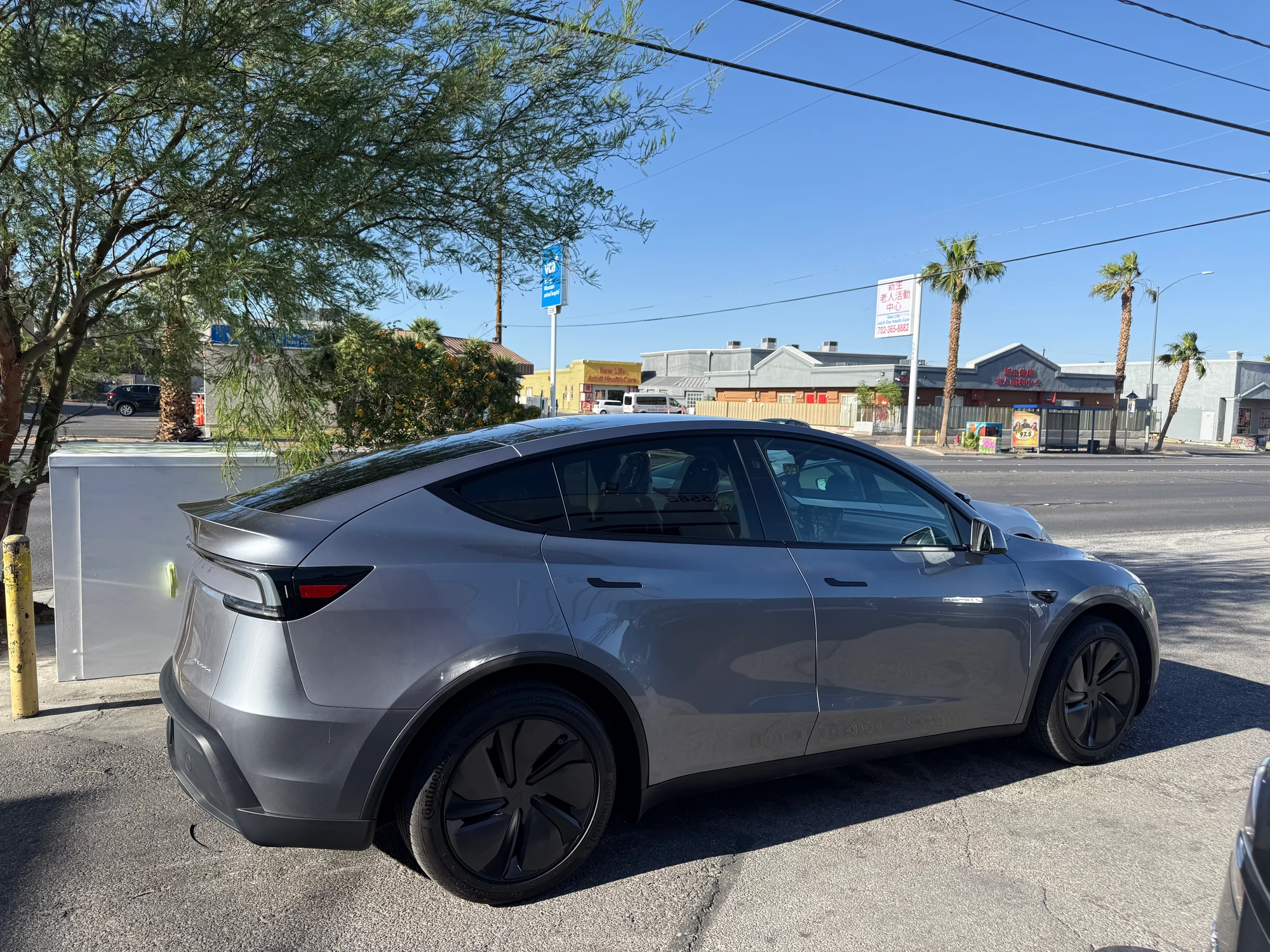 Gray Tesla with repaired passenger-side doors and body panels at Universal Motorcars in Las Vegas