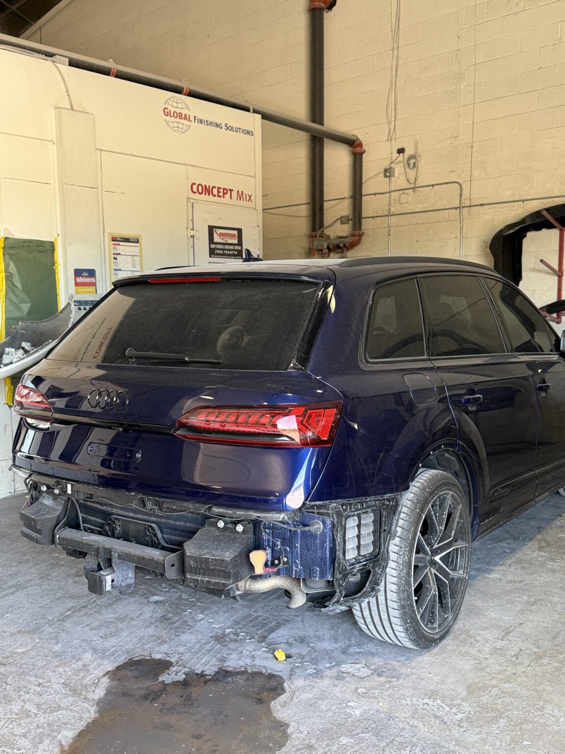 Blue Audi SUV rear quarter with bumper cover removed, revealing reinforcement and attachment areas