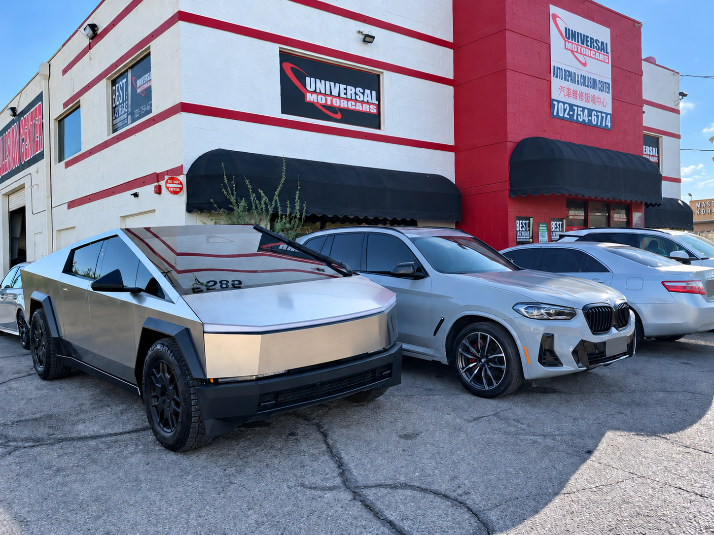 Silver Cybertruck outside Universal Motorcars, with the shop's signs above the vehicles