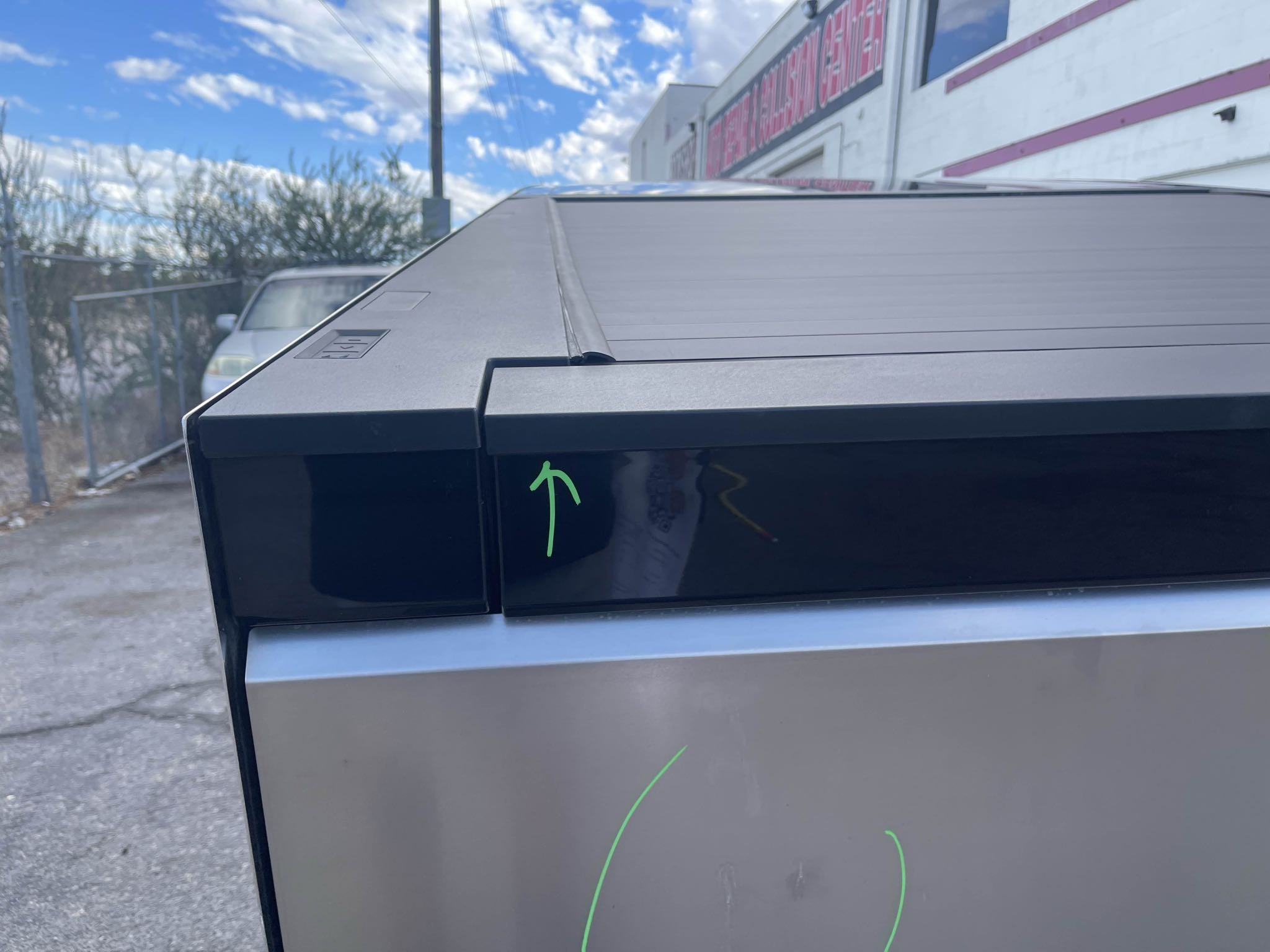 Green inspection markings on the Cybertruck tailgate and upper trim area