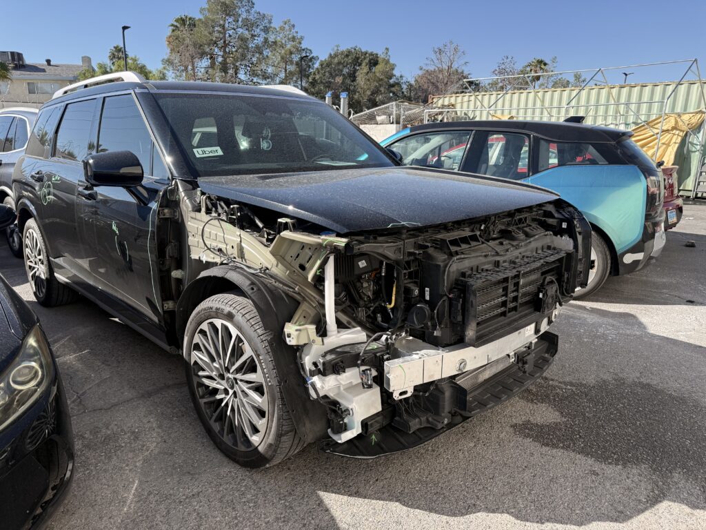 SUV with the front bumper cover and fender removed to inspect underlying collision damage