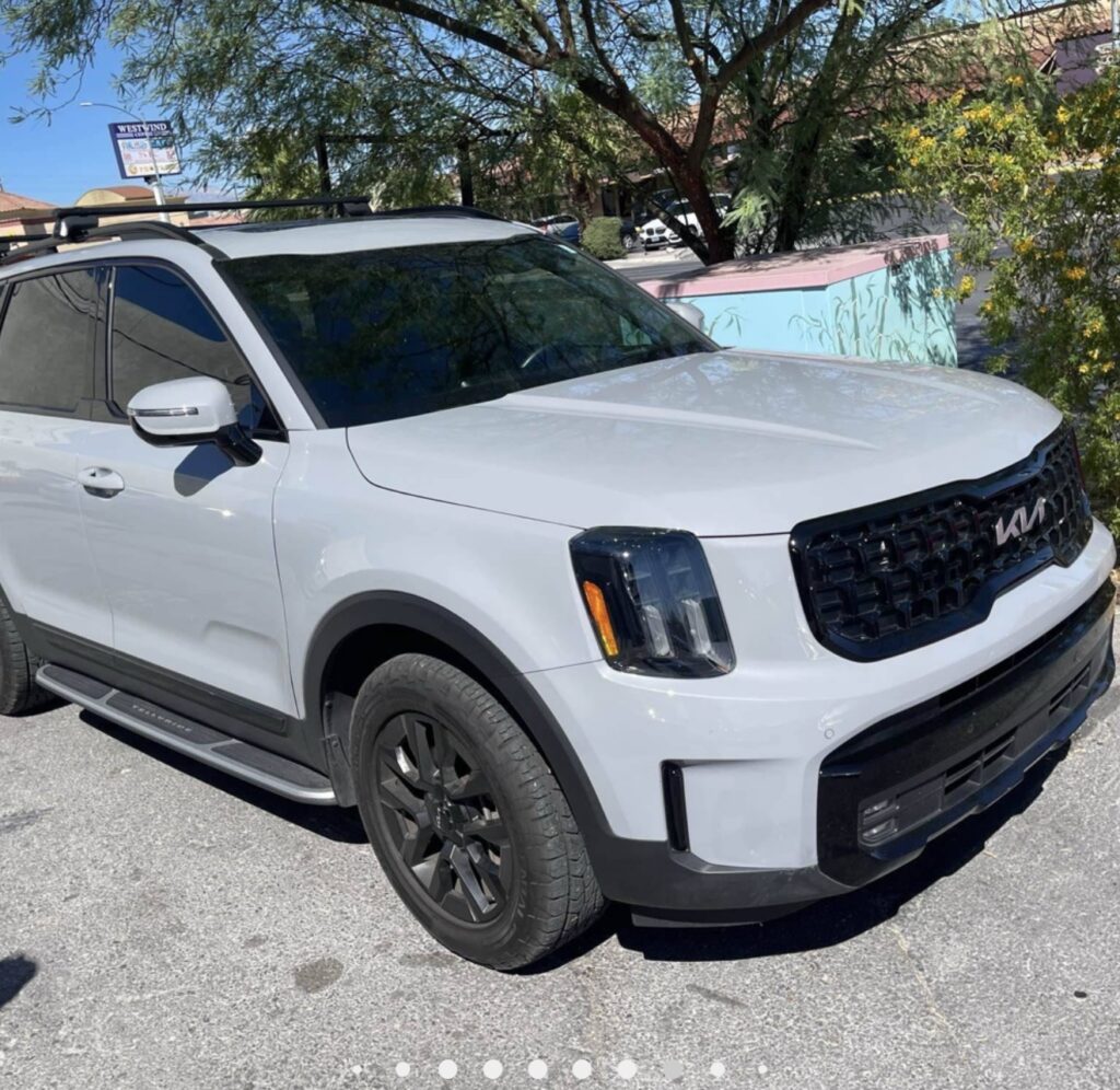White Kia Telluride viewed from the front passenger side outside Universal Motorcars.