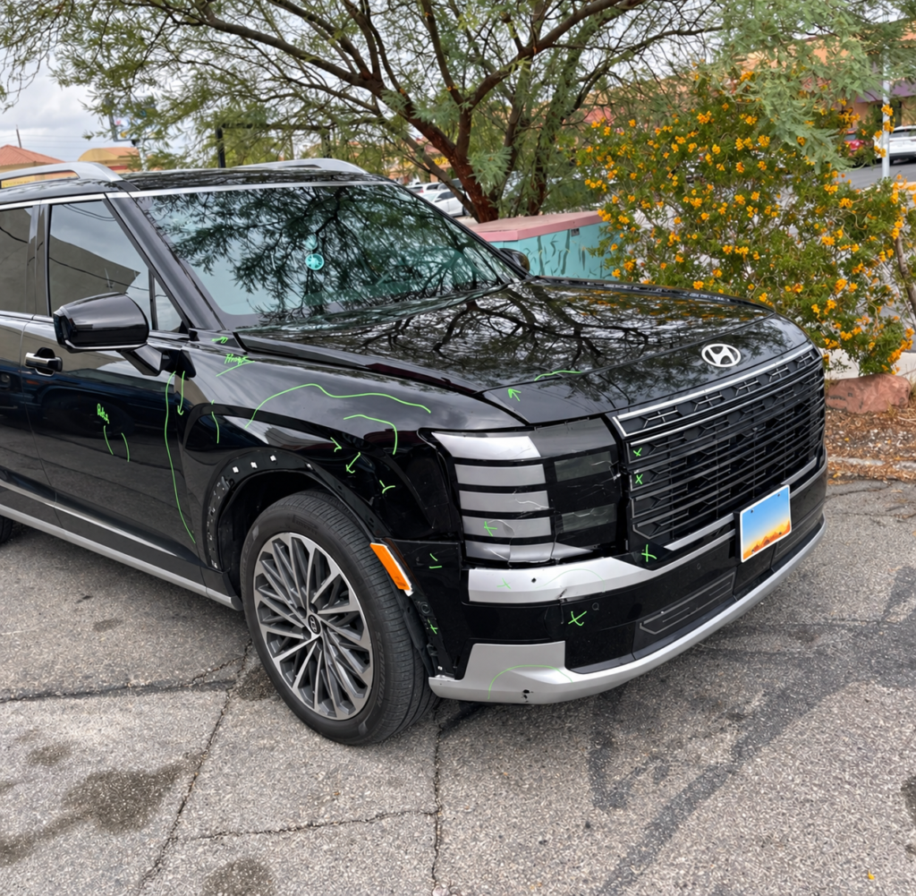 Black Hyundai SUV with front-corner collision damage and green inspection markings