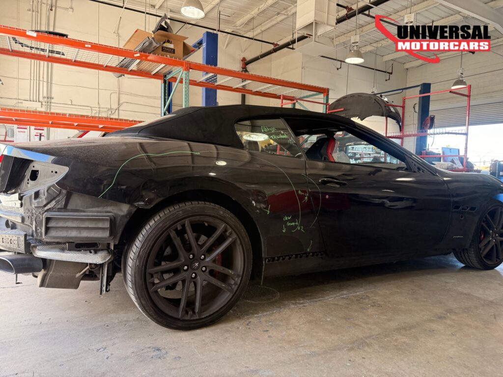 Maserati convertible with marked rear quarter-panel damage and the bumper removed at Universal Motorcars