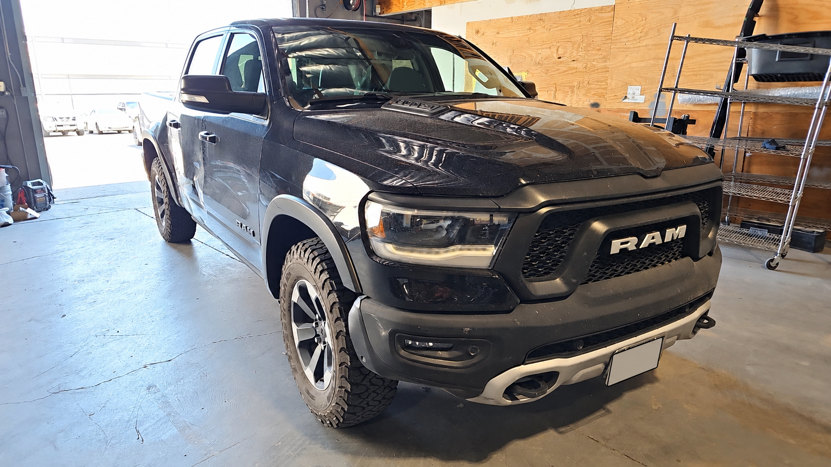Black Ram pickup inside the workshop, shown from the front passenger-side corner