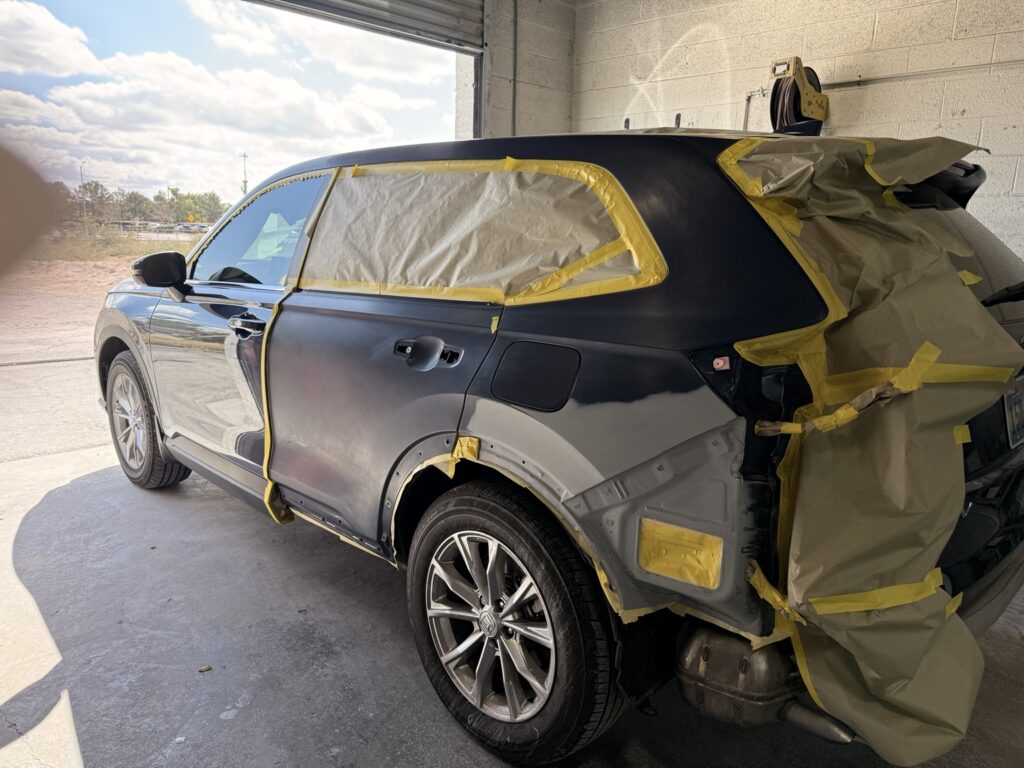 SUV rear door and quarter panel masked and prepared for refinishing at Universal Motorcars