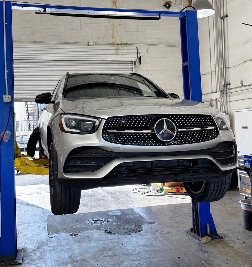 Silver Mercedes-Benz SUV on a lift inside the Universal Motorcars workshop