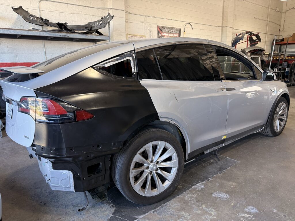 Silver Tesla Model X with an unpainted replacement rear quarter panel fitted before refinishing