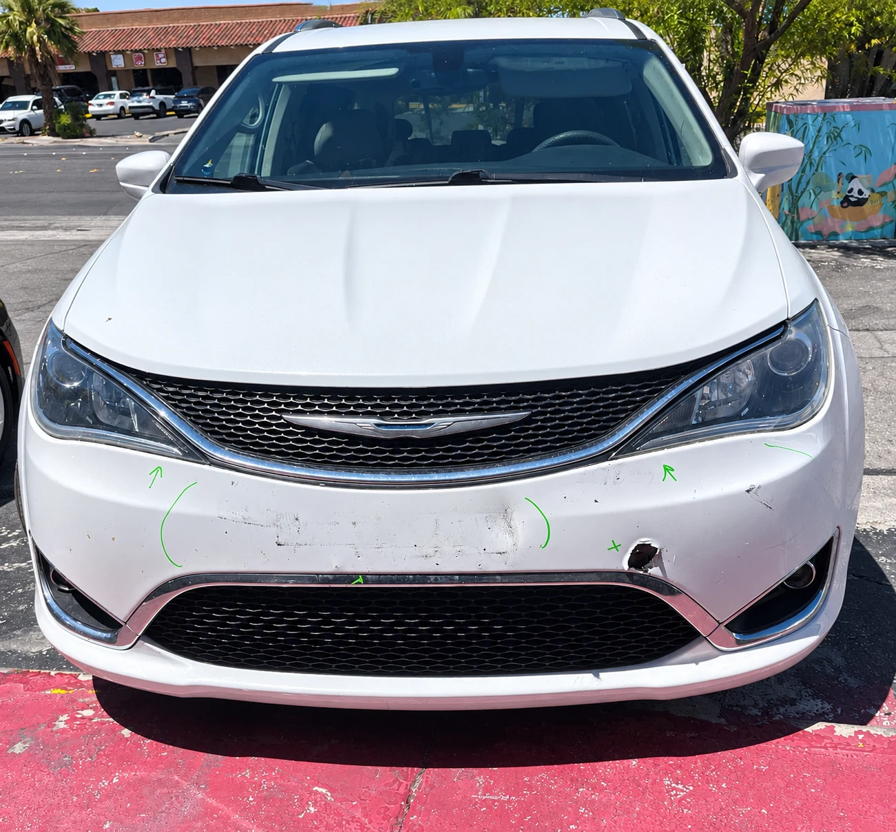 Chrysler Pacifica with front bumper scratches and puncture damage at Universal Motorcars in Las Vegas
