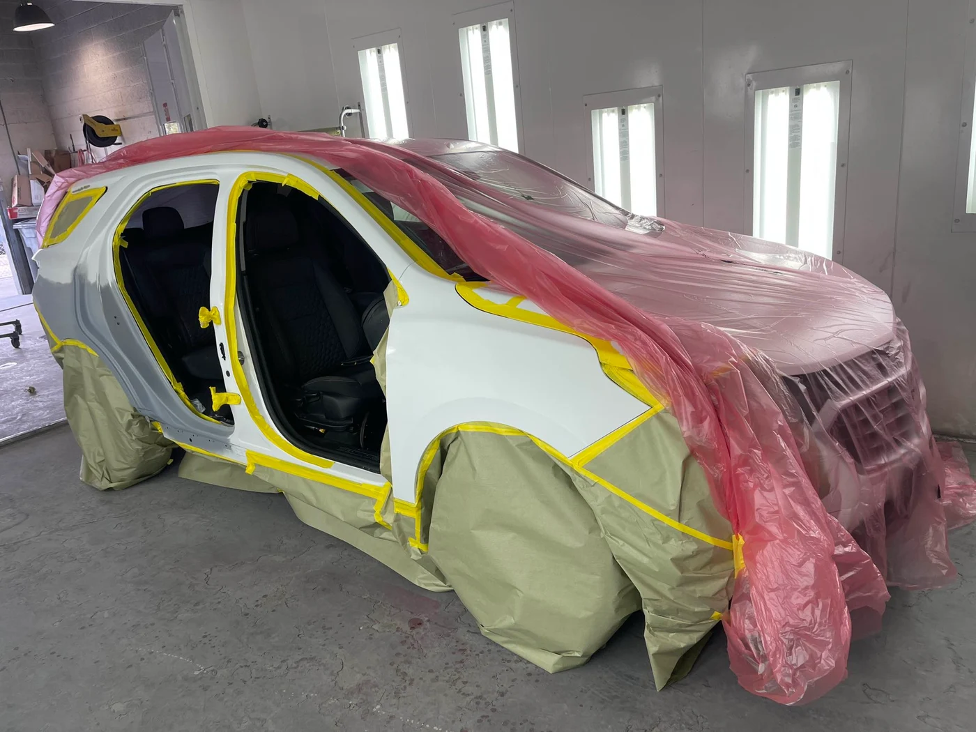 Vehicle masked and prepared for refinishing in the Universal Motorcars paint booth