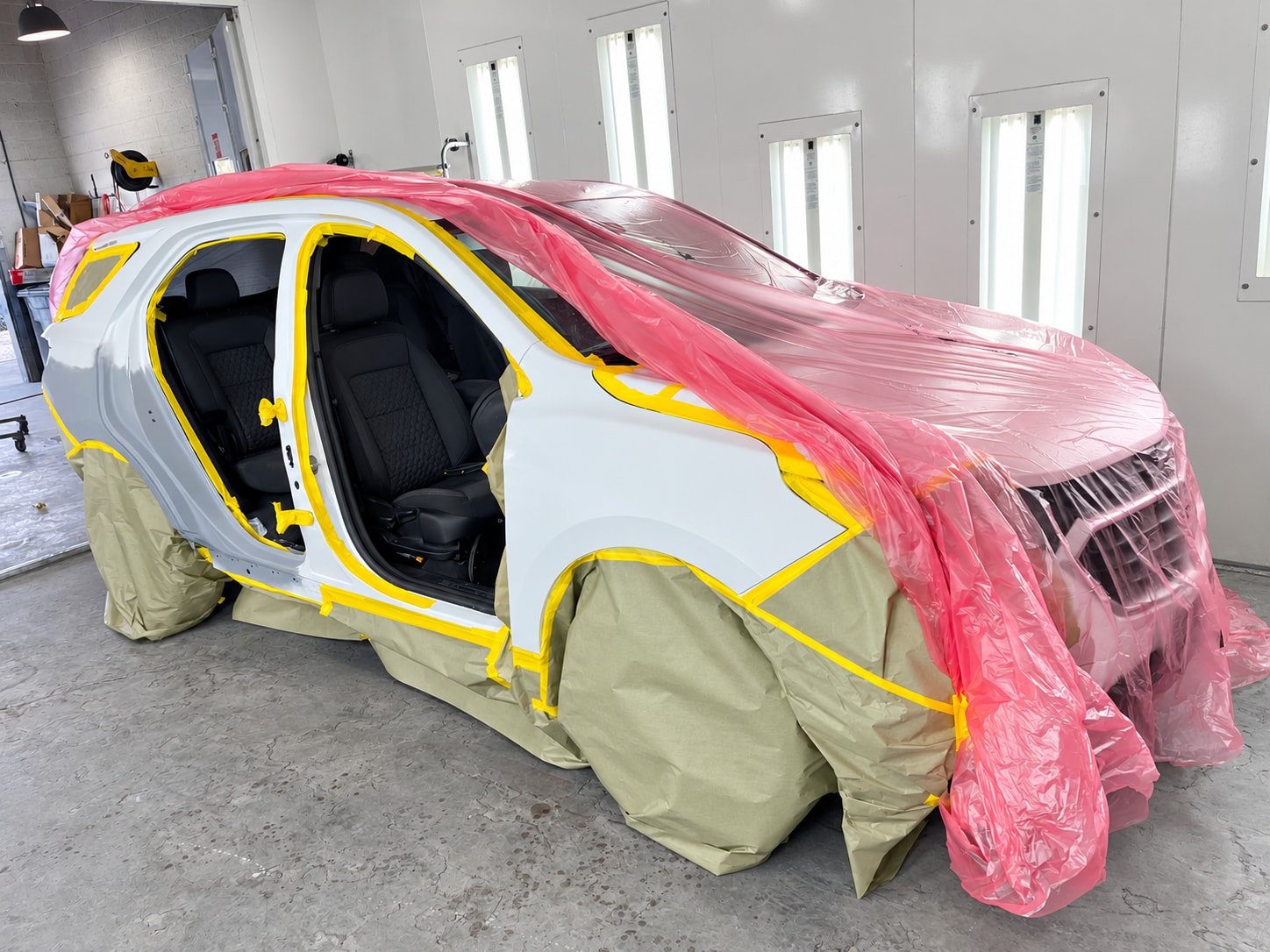 White Buick masked for refinishing in the Universal Motorcars Las Vegas paint booth