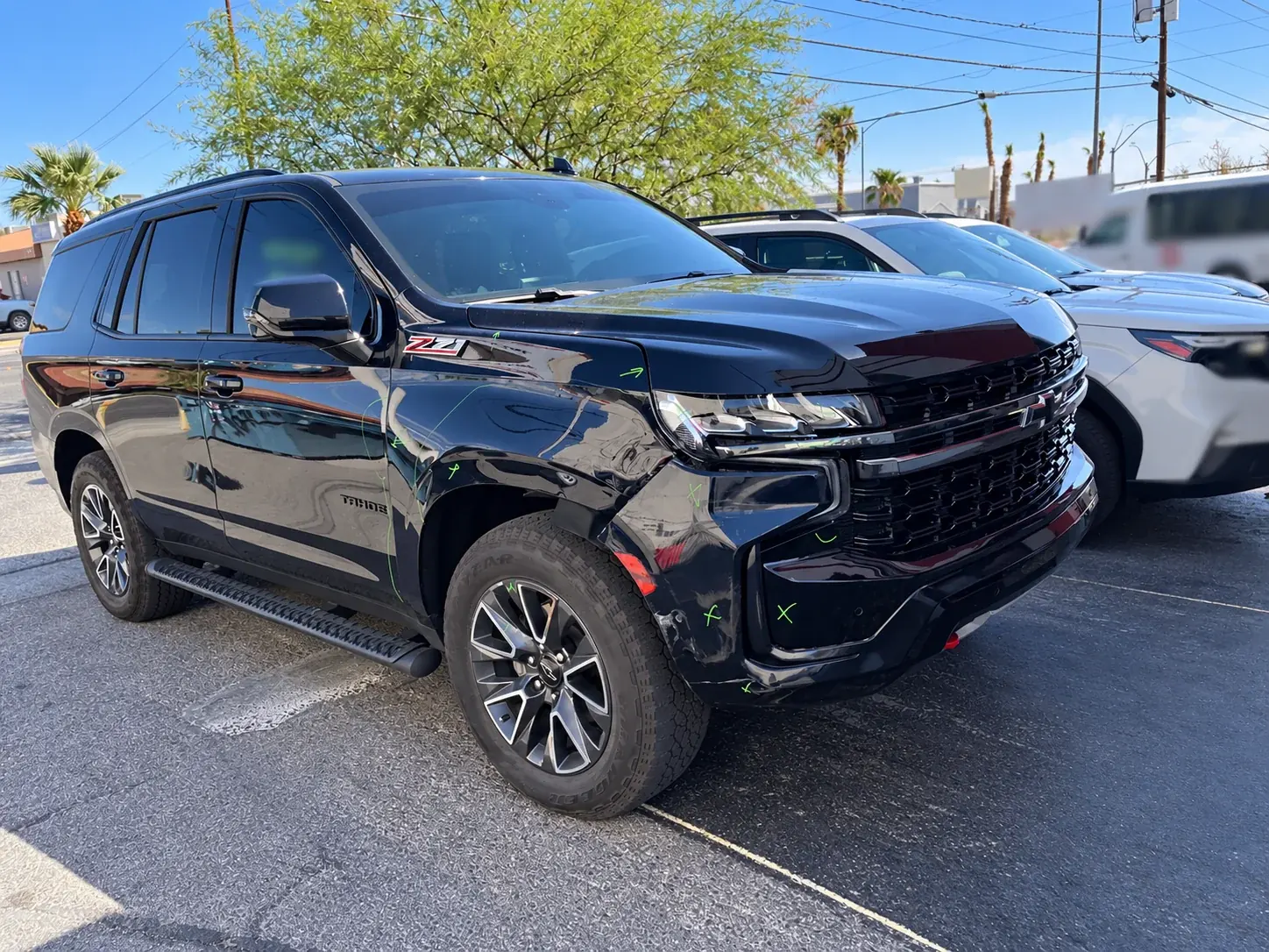 Black Chevrolet Tahoe Z71 with repair markings on its front door and side panels.