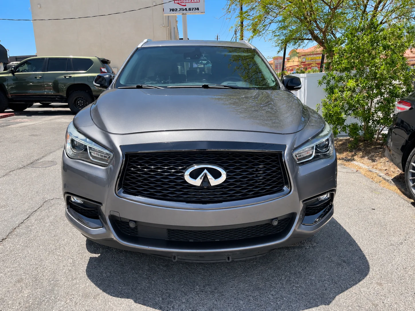 Front view of a gray INFINITI SUV showing its grille, headlights and bumper.