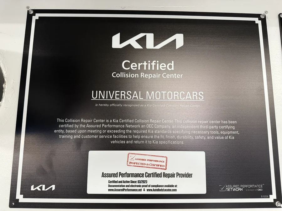 Kia Certified Collision Repair Center plaque naming Universal Motorcars