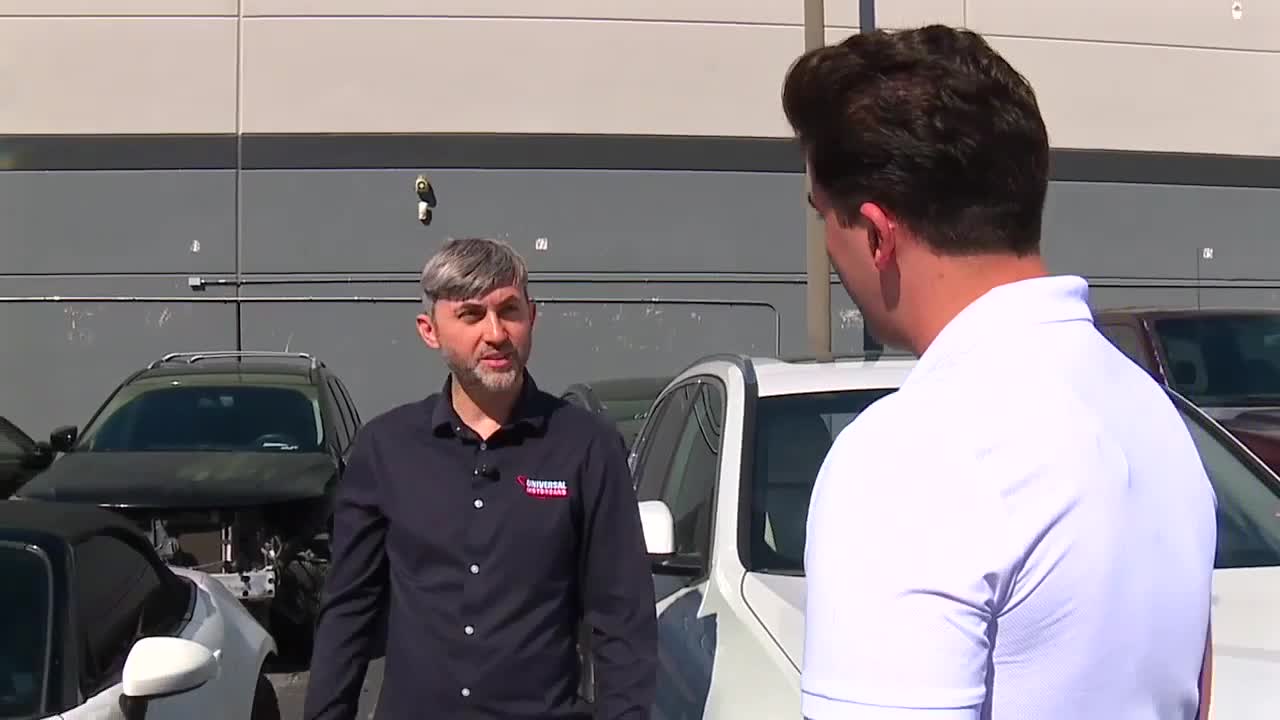Victor Botnari speaking with KTNV reporter Abel Garcia outside Universal Motorcars
