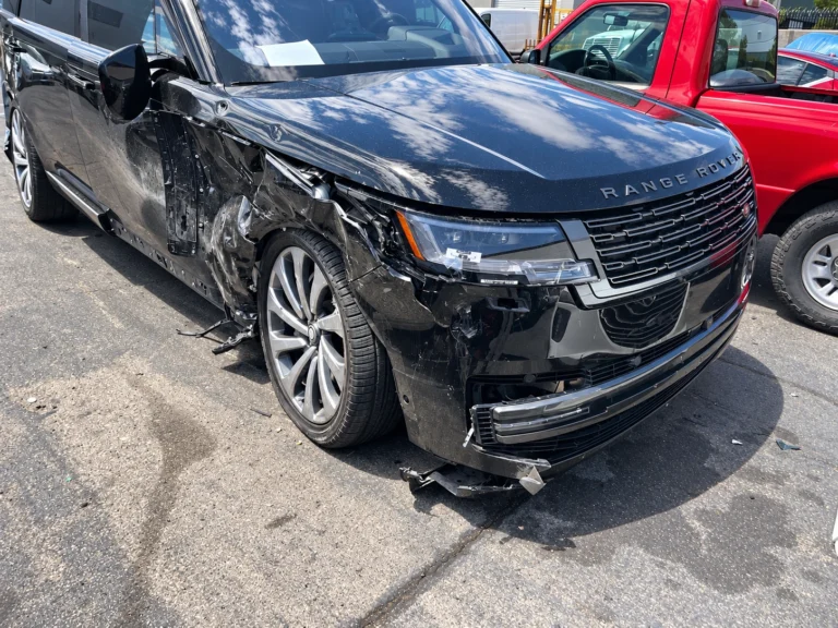 Black Range Rover with visible front bumper, front fender and side-door damage.