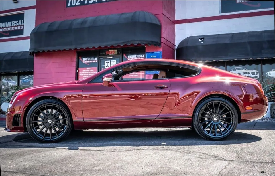 Side profile of the red Bentley Continental GT after refinishing