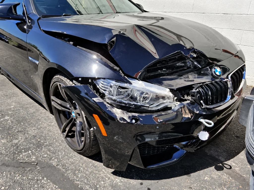 The same blue BMW before repair, with a buckled hood and damaged front bumper