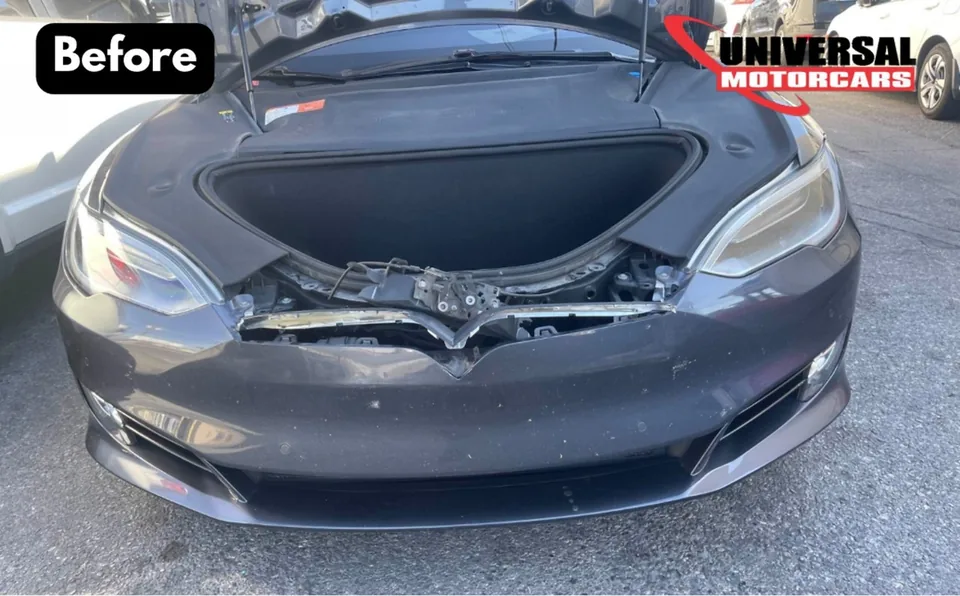 Gray Tesla Model S with front bumper collision damage and its hood open