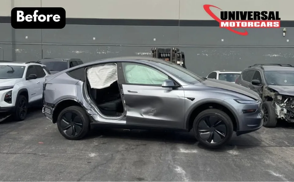 Gray Tesla Model Y with its passenger-side rear door removed during collision repair