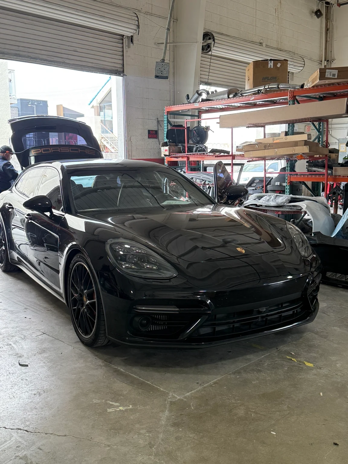 Black Porsche Panamera in the Universal Motorcars workshop with its rear hatch open