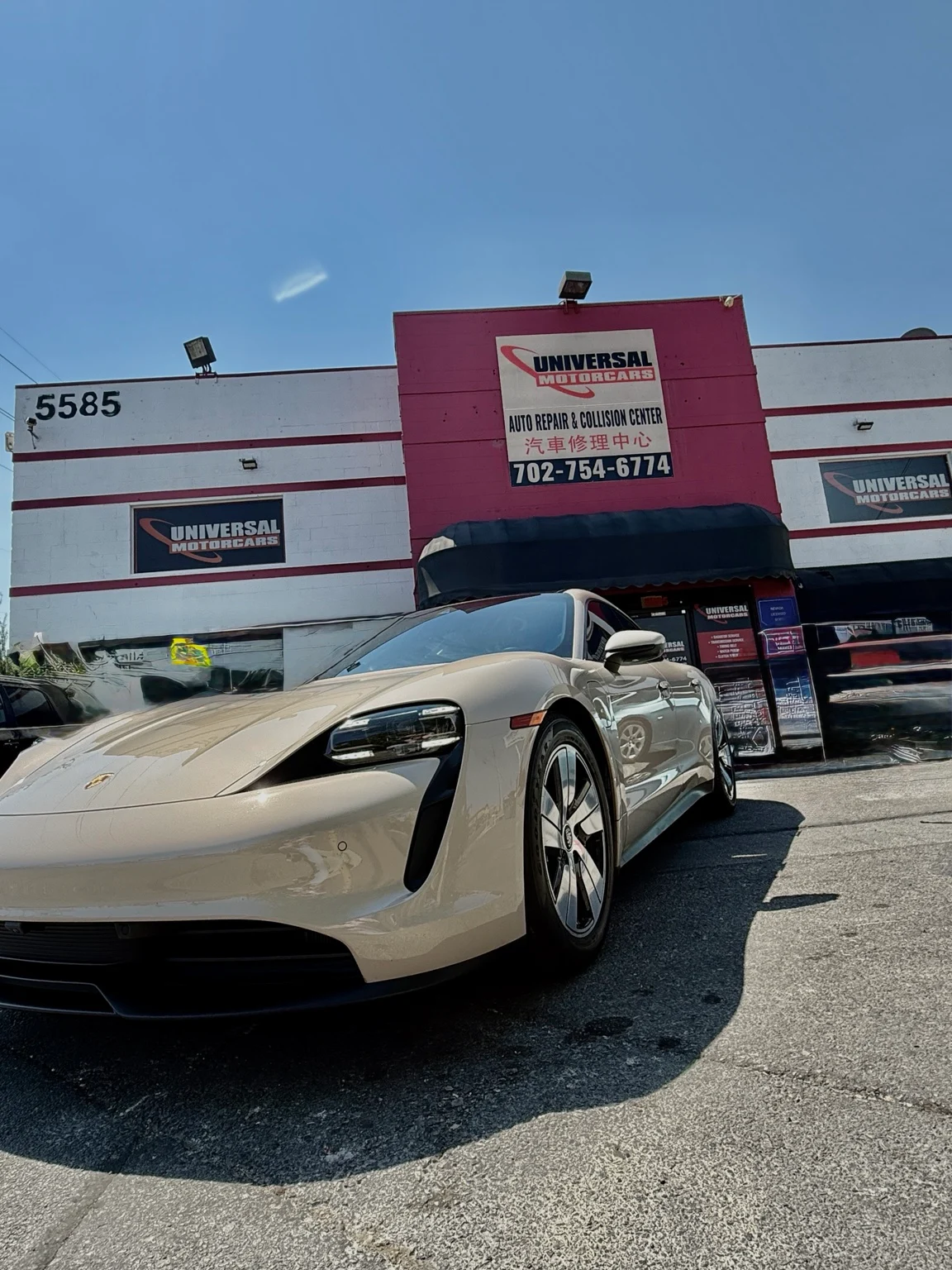Porsche Taycan showing its front bumper, headlamp and front wheel outside Universal Motorcars