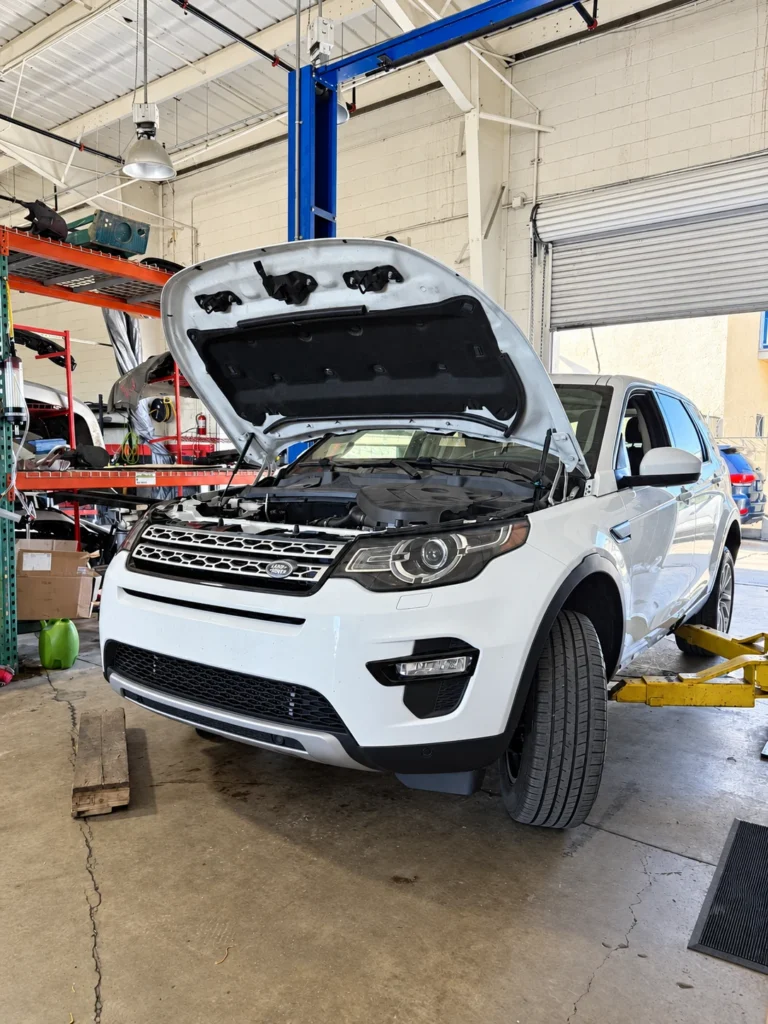 Land Rover Discovery Sport with its hood open in the Universal Motorcars workshop.