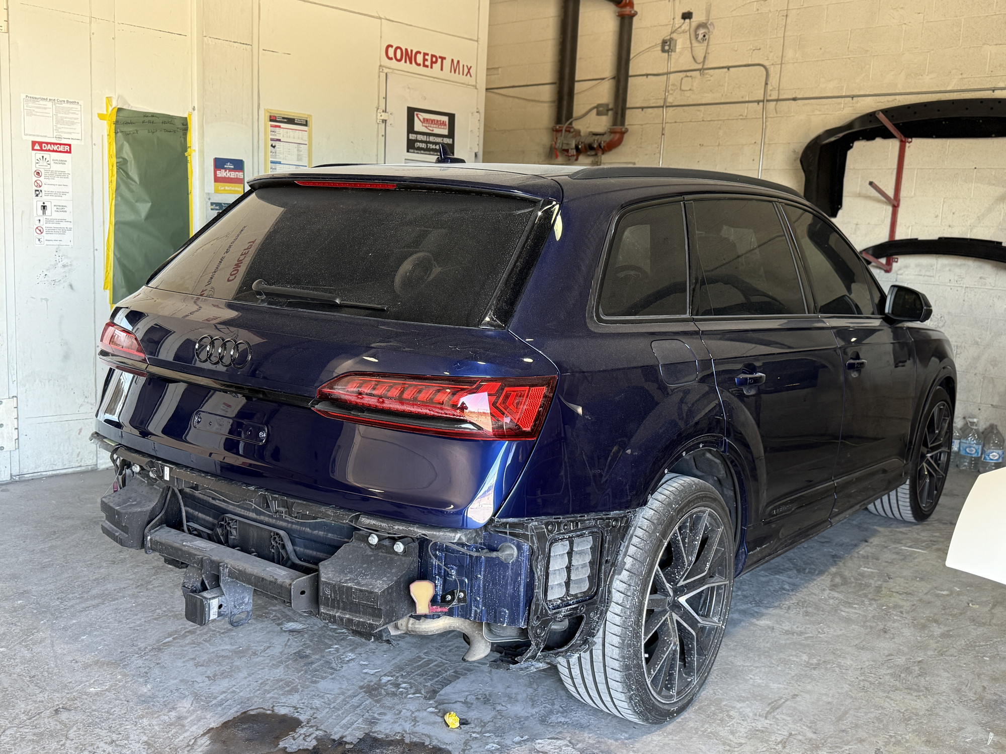Blue Audi Q5 with the rear bumper removed inside a Universal Motorcars workshop