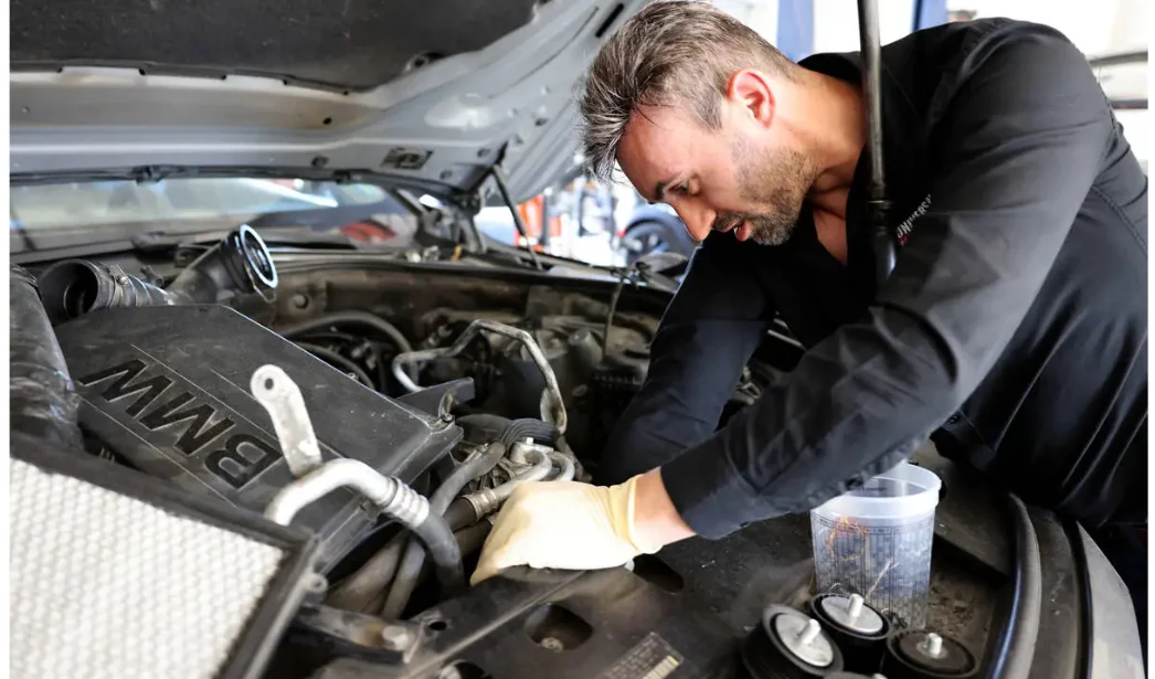 Victor Botnari, owner of Universal Motorcars, working on belts and a pulley in an engine bay; photographed by K.M. Cannon for the Las Vegas Review-Journal